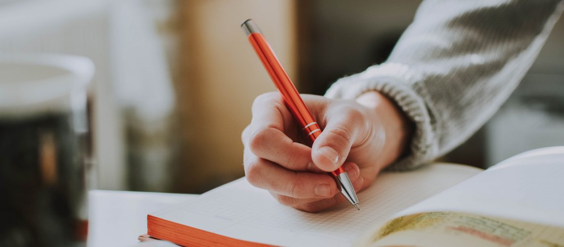 person-holding-orange-pen-1925536 person-holding-orange-pen-1925536